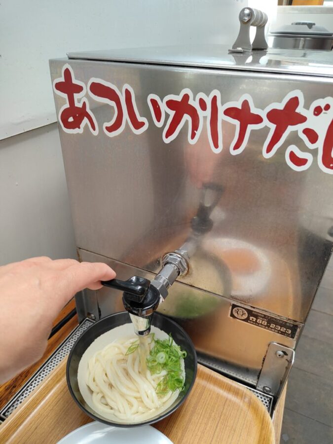 山越うどんのかけ出汁を注ぐ