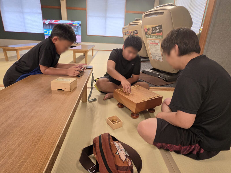 つばさ山温泉の休憩所で将棋をする親子