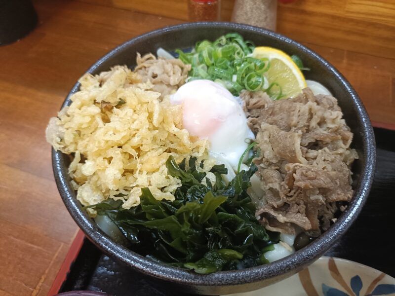 麺処綿谷高松店の牛肉と豚肉、温泉卵、わかめ、レモンが豪快に乗ったスペシャルぶっかけうどん(小・あつあつ)