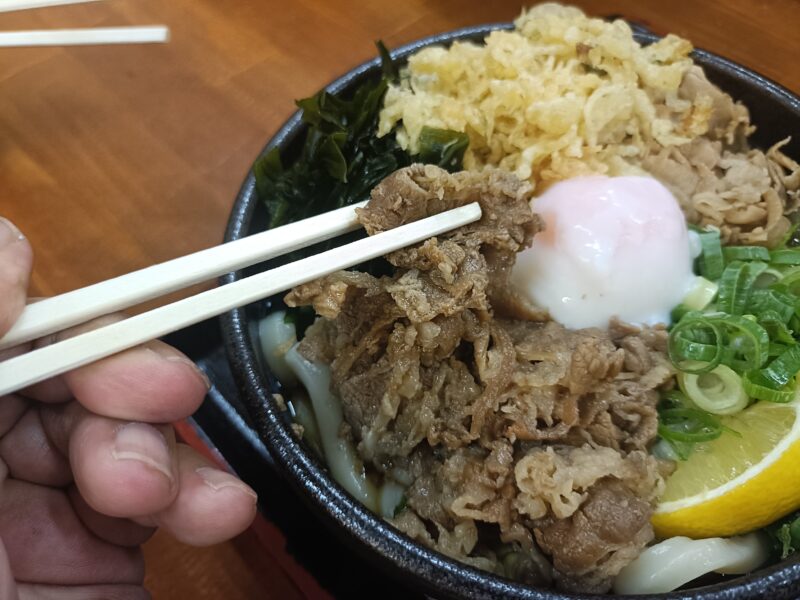 麺処綿谷高松店のスペシャルぶっかけうどんにトッピングされた、甘辛く煮込まれたジューシーな牛肉のアップ