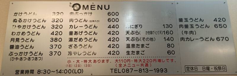 麺処綿谷高松店のボリューム満点なうどんメニューが書かれた、店内の大きな壁掛けメニュー表