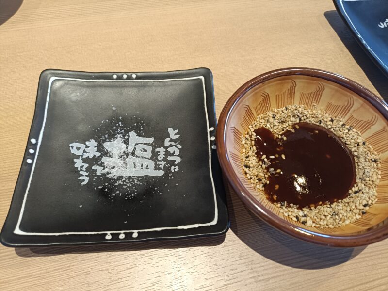 山かつ屋島店のとんかつを食べるために準備をした塩とごまにとんかつソースをかける