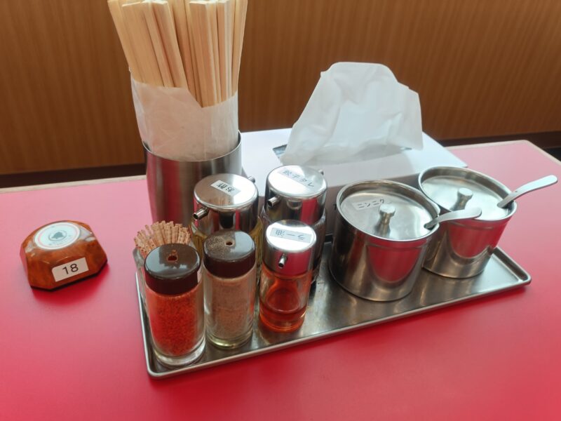 山岡家高松の卓上にある調味料たち（餃子タレ、お酢、一味、胡椒、ラー油、ニンニク、豆板醤）